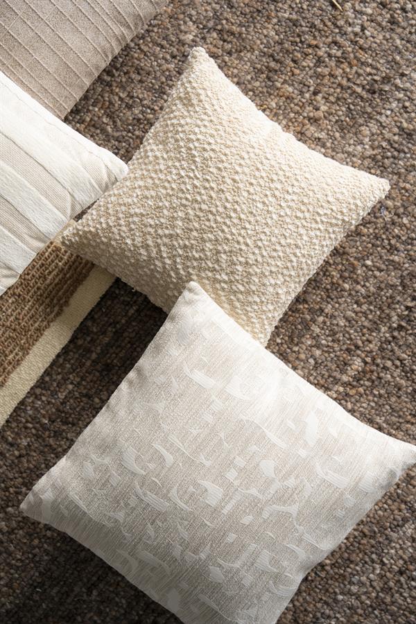 By Boo Dara beige met grafisch dessin naast lichte kussens met verschillende structuren